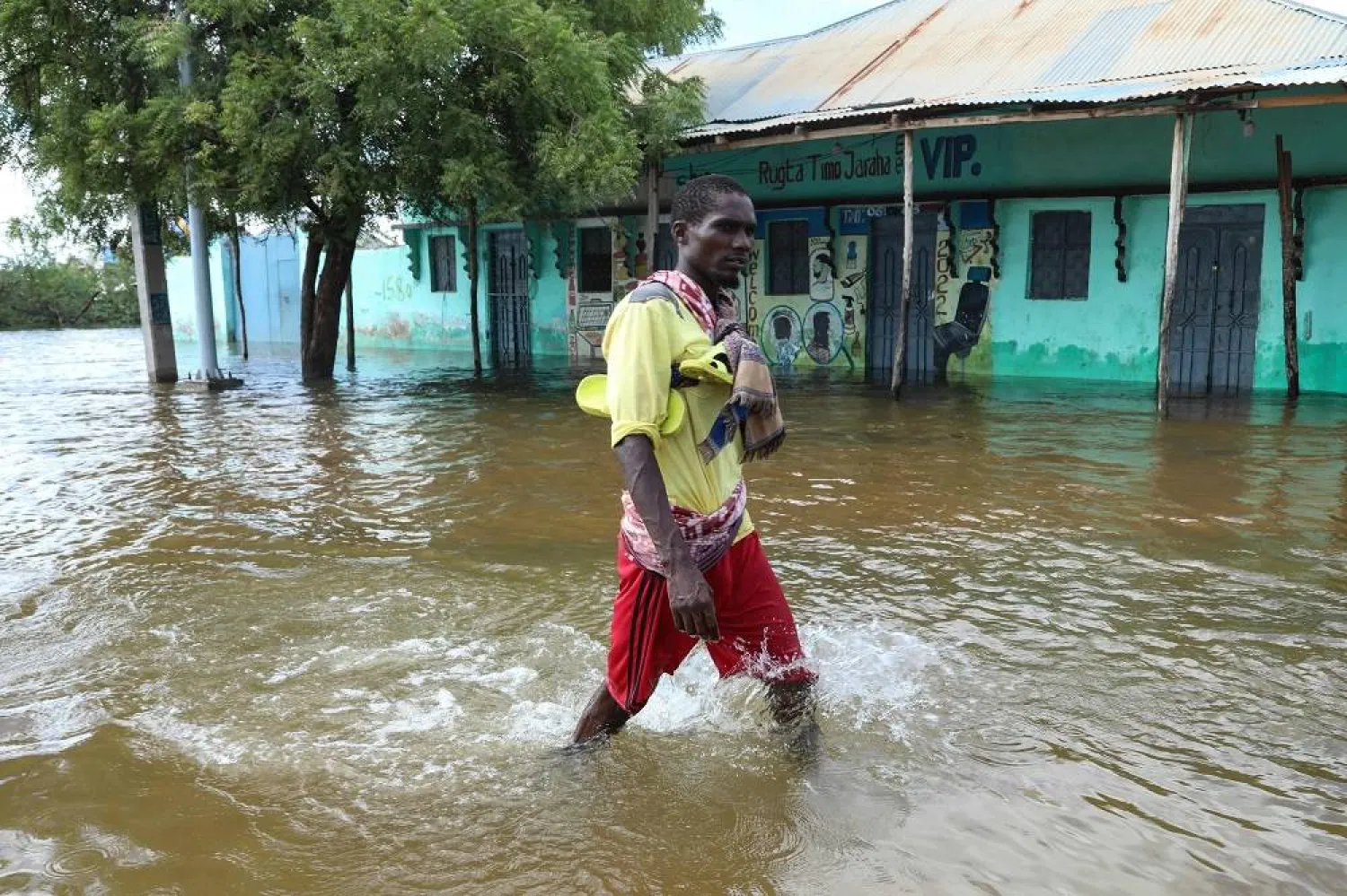 A man walks through floodwater in Beledweyne, central Somalia, on May 13, 2023. (AFP) 