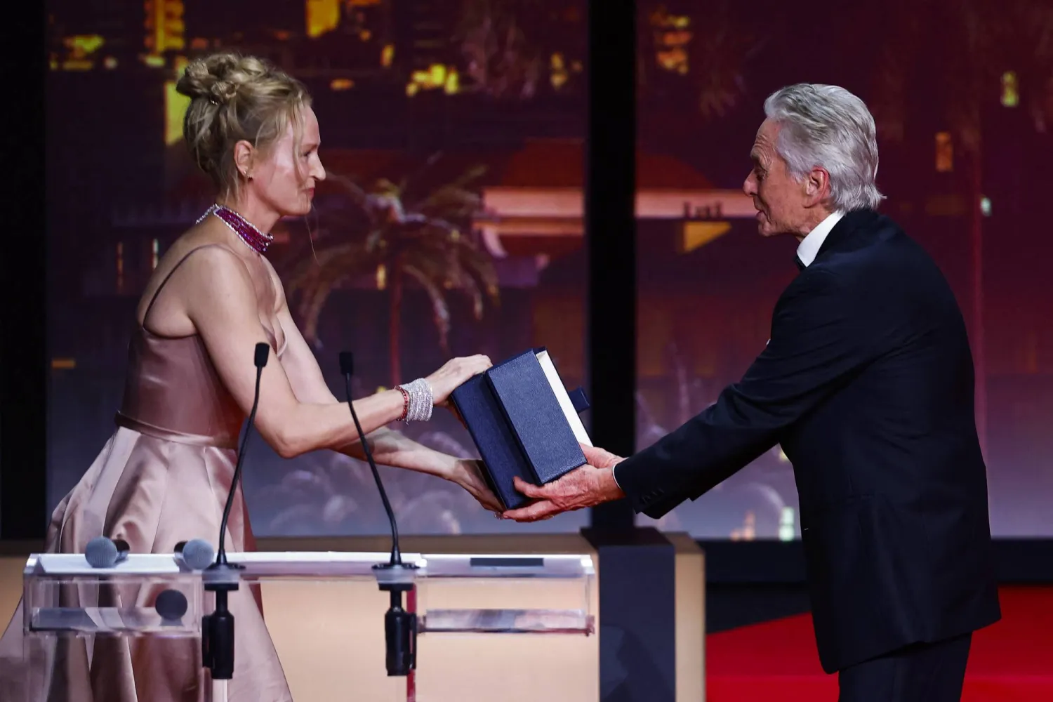 The 76th Cannes Film Festival - Opening ceremony and screening of the film "Jeanne du Barry" Out of competition - Cannes, France, May 16, 2023.  Michael Douglas receives the Honorary Palme d'Or Award from Uma Thurman. REUTERS/Eric Gaillard