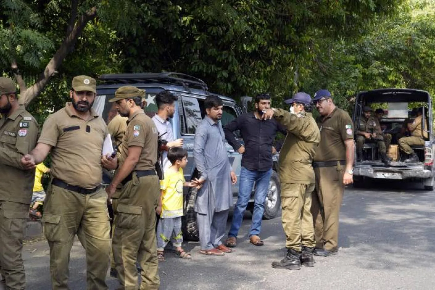 Police officers search a man at a temporary checkpoint around the home of Pakistan's former Prime Minister Imran Khan, in Lahore, Pakistan, Wednesday, May 17, 2023. (AP Photo/K.M. Chaudary)
