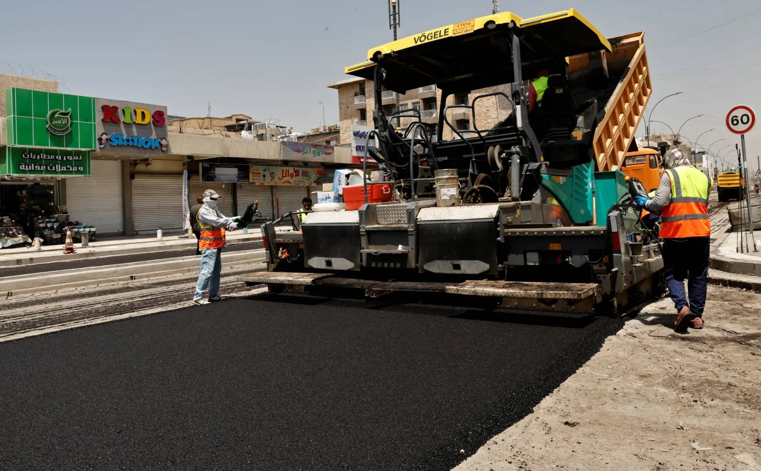 Iraqi workers lay asphalt as a Al-Karada street is paved in Baghdad, Iraq May 12, 2023. REUTERS/Thaier Al-Sudani