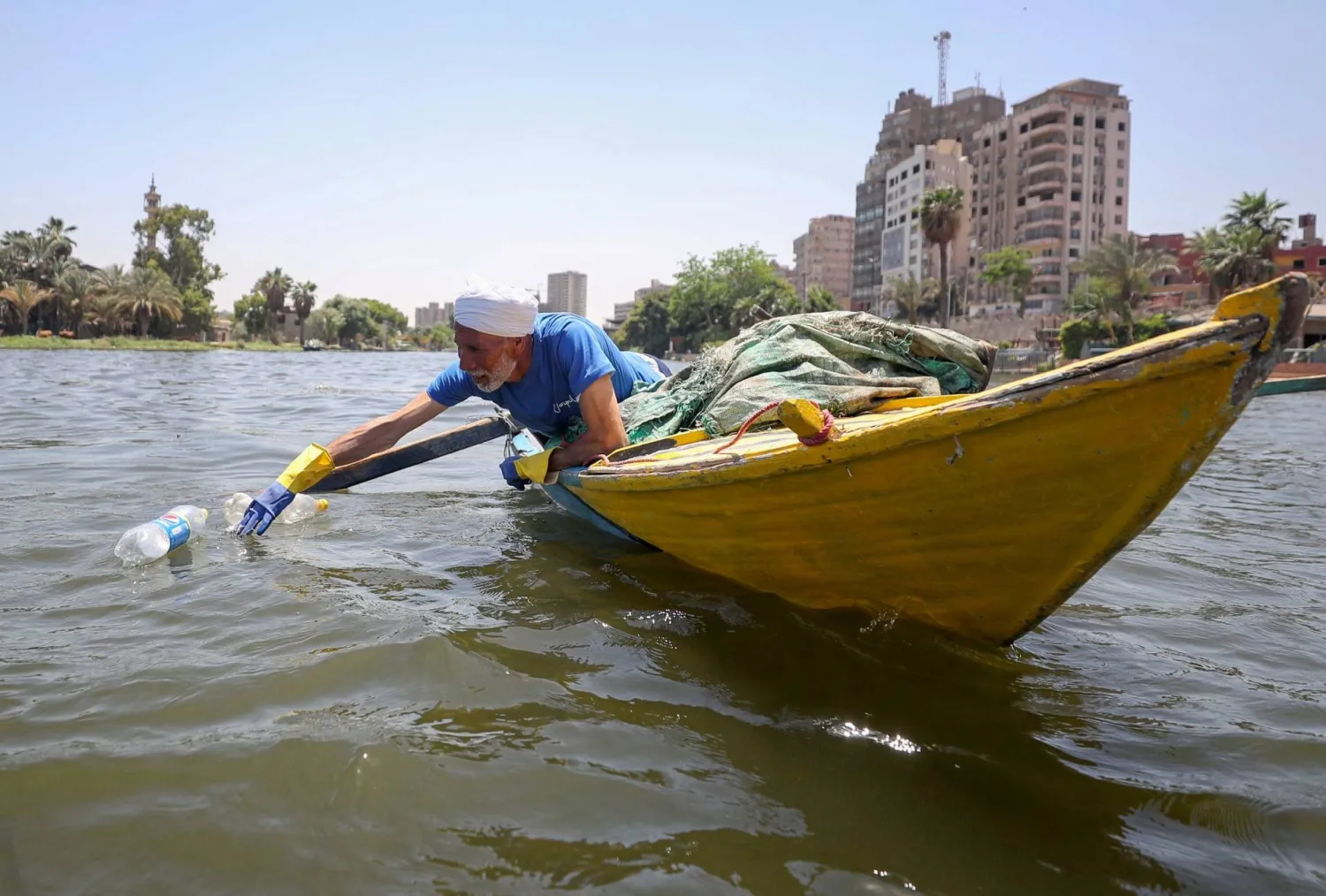 A fisherman uses his boat to collect plastic garbage from the Nile River in Giza, Egypt May 20, 2021. REUTERS/Mohamed Abd El Ghany