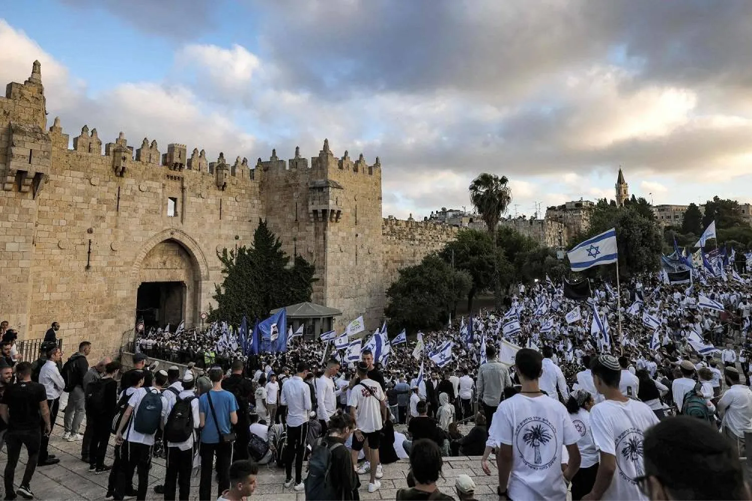 Israelis waving national flags gather in front of Damascus Gate leading to the Old City of Jerusalem, during the annual “flags march” to mark “Jerusalem Day”, on May 18, 2023. (AFP) 