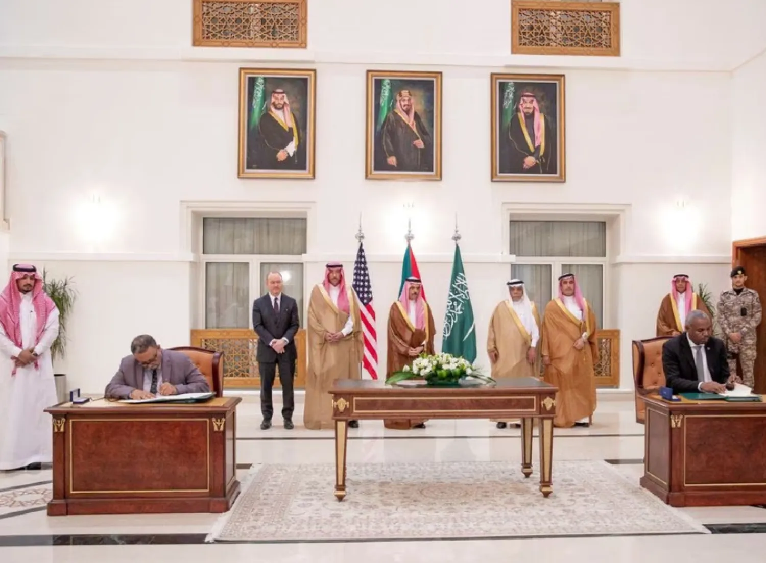 Saudi Foreign Minister Prince Faisal bin Farhan bin Abdullah Al-Saud stands along with other officials as representatives of the Sudanese army and rival paramilitary Rapid Support Forces sign an agreement for a seven-day ceasefire in Jeddah, Saudi Arabia, May 20, 2023. Saudi Press Agency/Handout via REUTERS 
