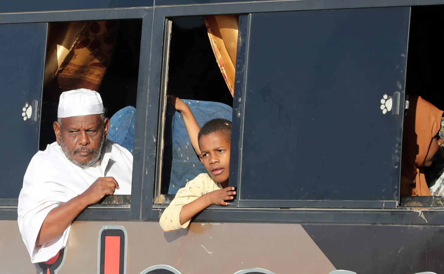 رجل سوداني وطفل يجلسان في حافلة في طريقهما إلى مصر هرباً من الصراعات في الخرطوم (إ.ب.أ)