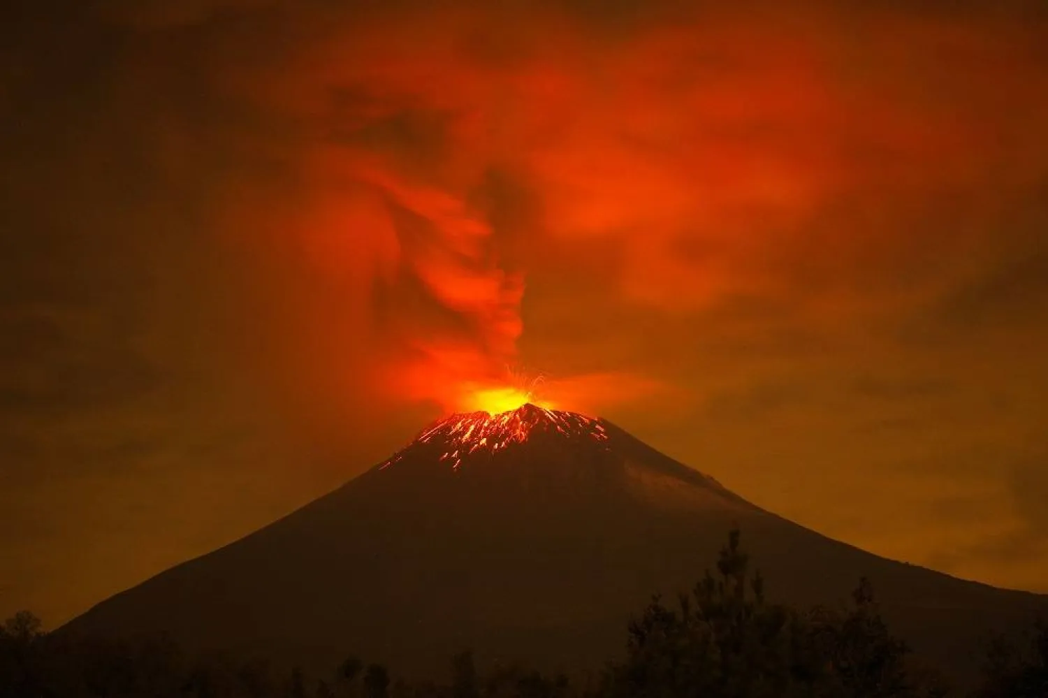 Incandescent materials, ash and smoke are spewed from the Popocatepetl volcano as seen from the San Nicolas de los Ranchos community, state of Puebla, Mexico, on May 23, 2023. (AFP) 