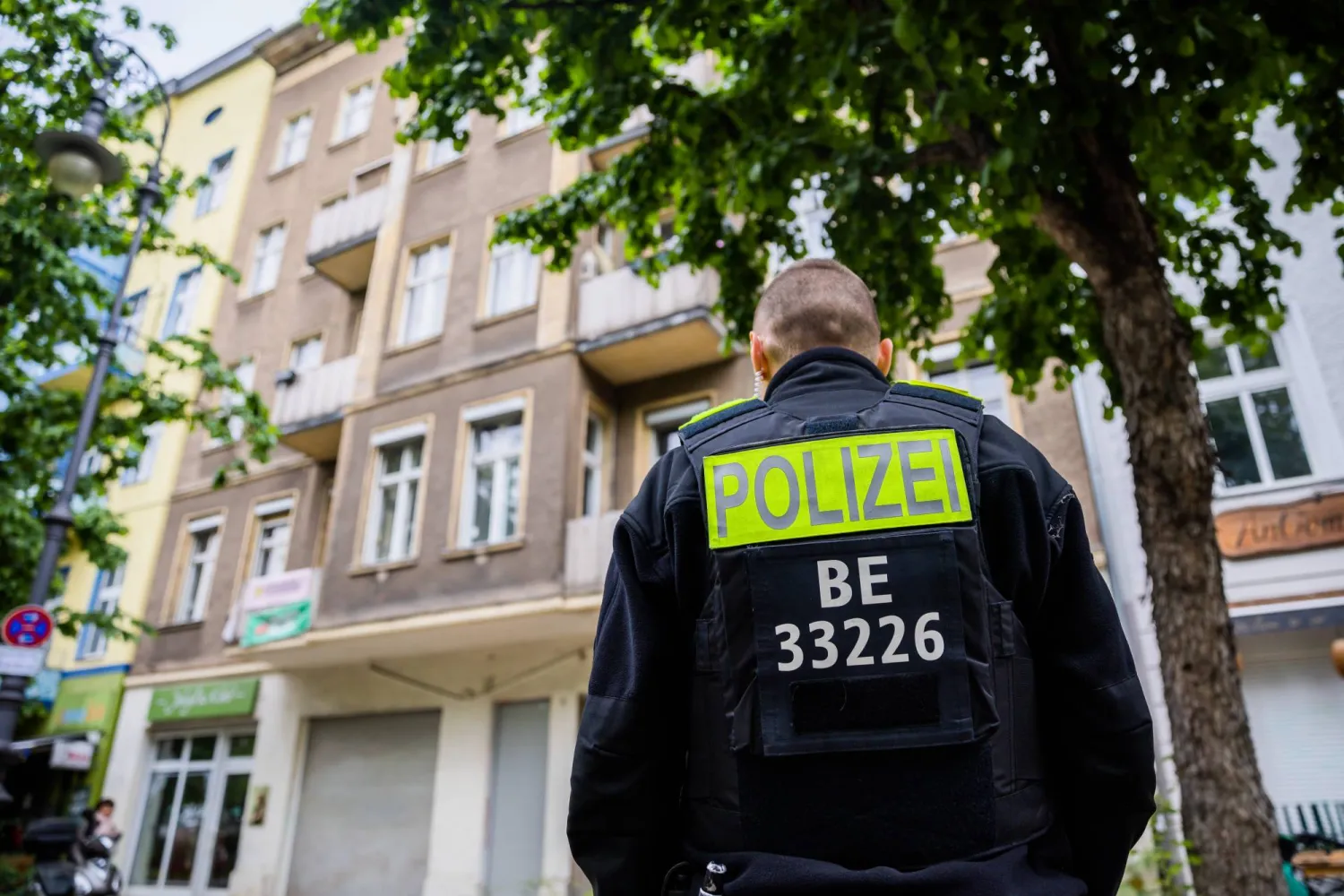 شرطي ألماني يقف أمام بناية خلال عملية مداهمة تستهدف نشطاء المناخ (د.ب.أ)