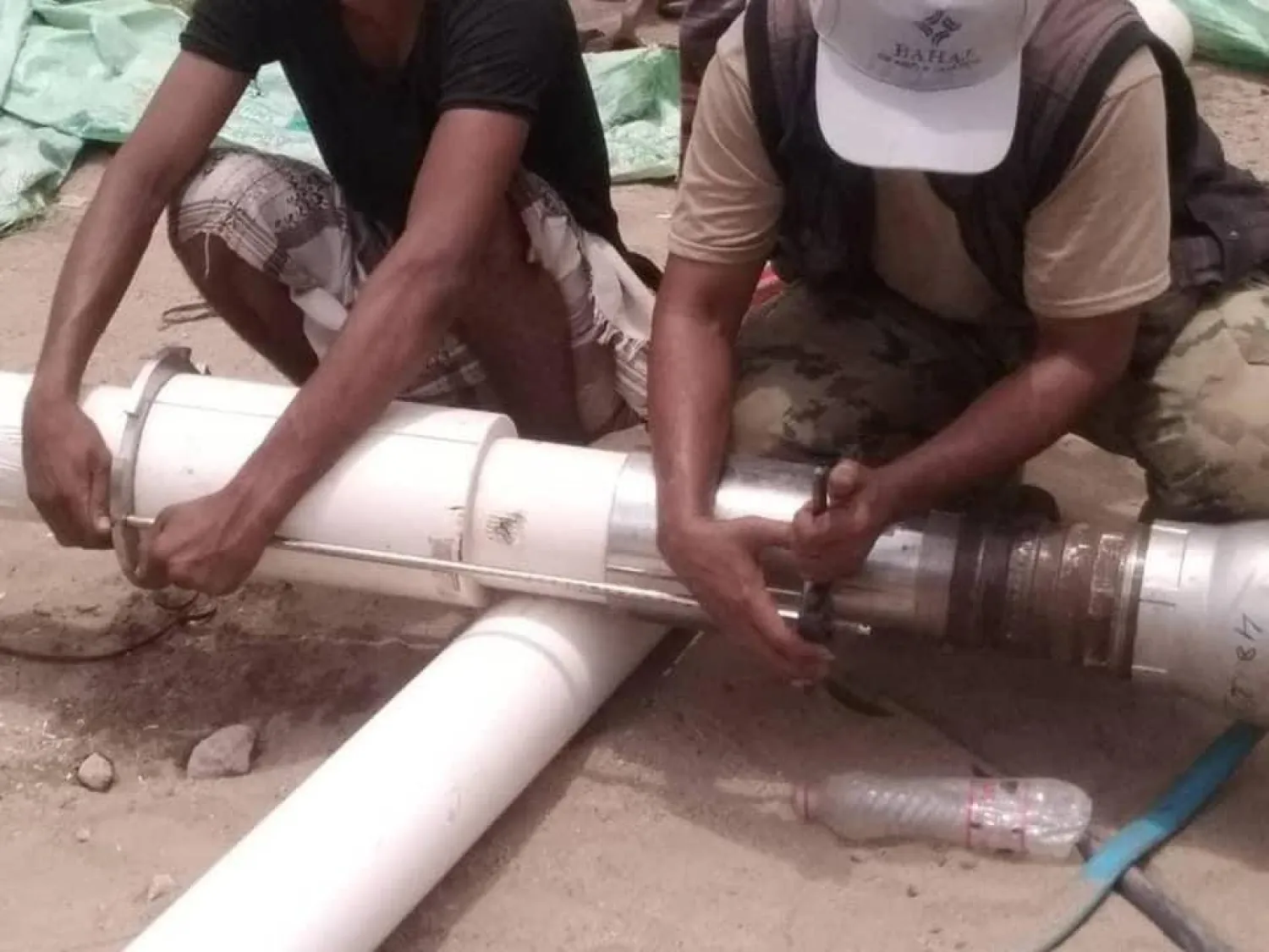 عمال يصلحون أنبوب ضخ المياه (مؤسسة المياه اليمنية)