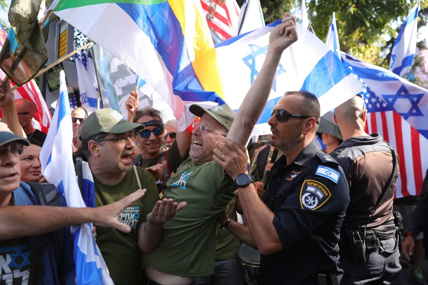 رجال شرطة بمواجهة متظاهرين يحتجون على سياسة الحكومة أمام منزل نتنياهو في القدس الخميس (إ.ب.أ)