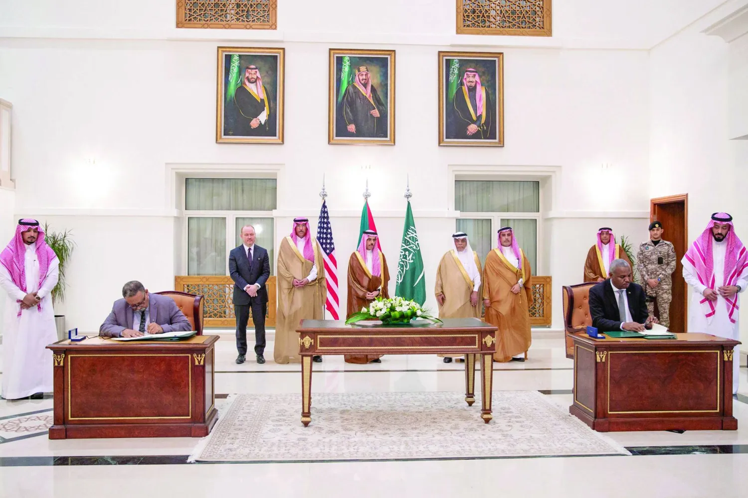 وزير الخارجية السعودي إلى جانب ممثلين عن طرفي النزاع السوداني خلال توقيع اتفاق جدة (رويترز)