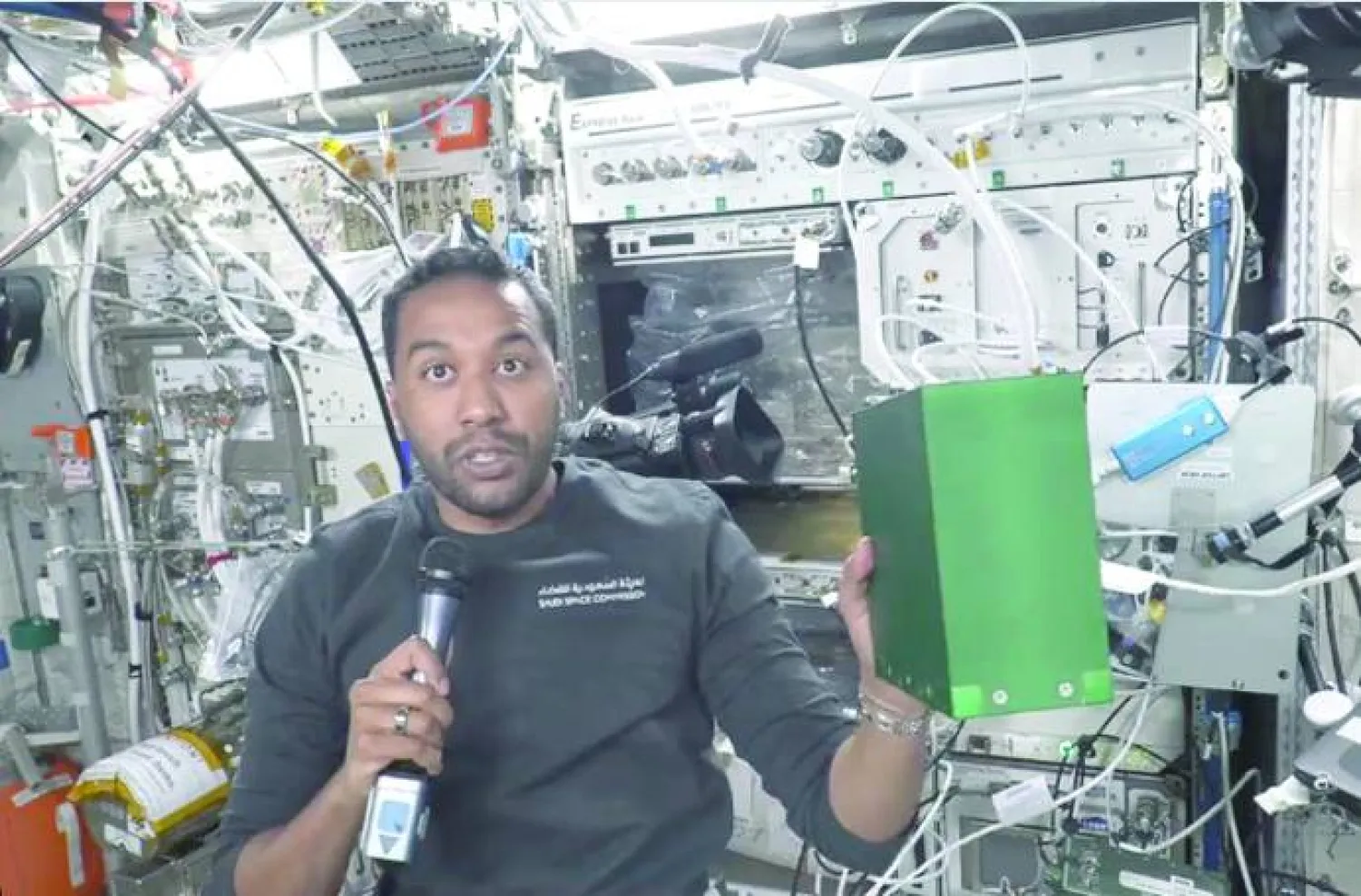 
علي القرني يحمل صندوقاً أخضر لتجربة الاستمطار الصناعي داخل وحدة كولومبوس