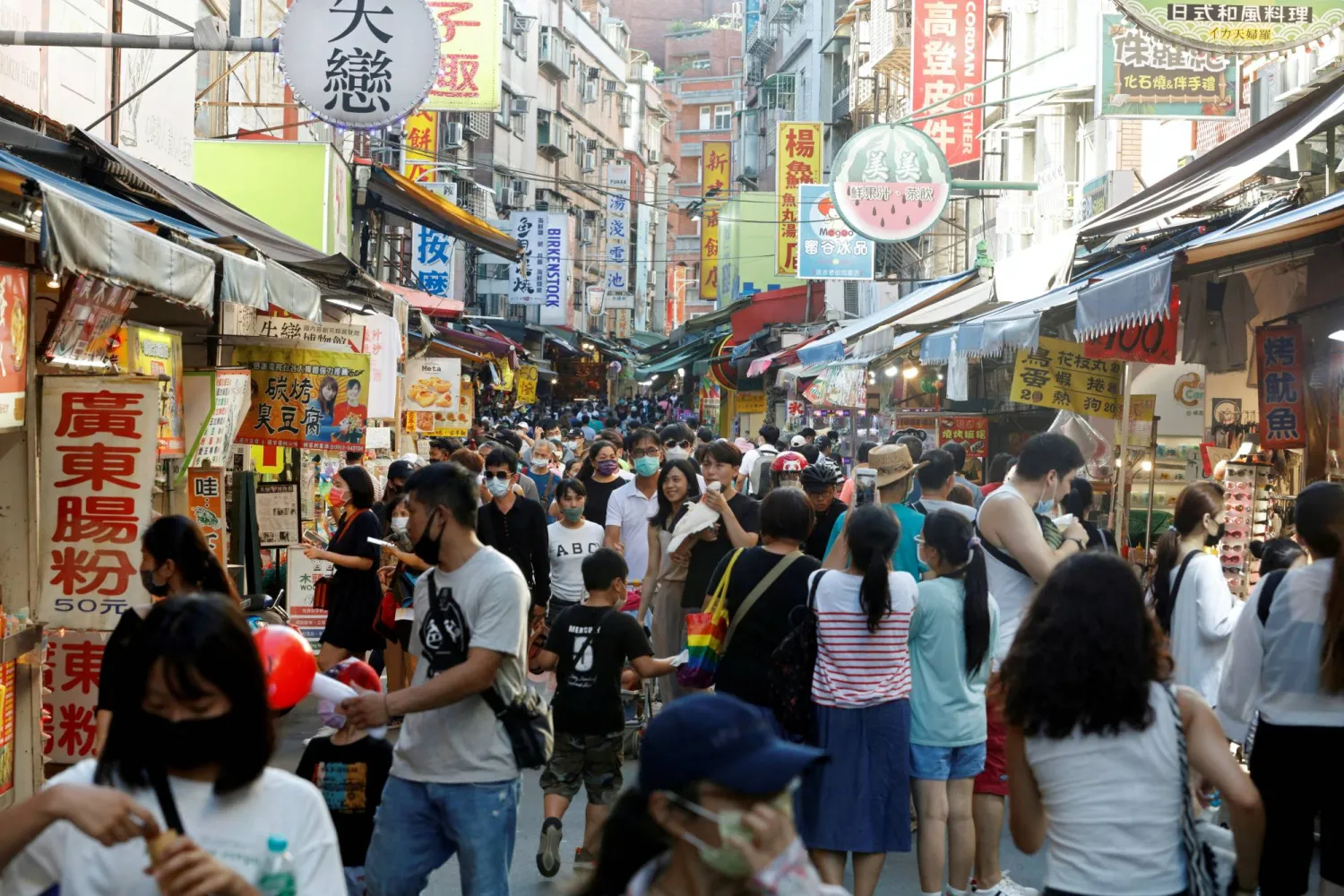 FILE PHOTO: People throng a street in Tamsui district of New Taipei City, Taiwan August 7, 2022. REUTERS/Jameson Wu/File Photo
