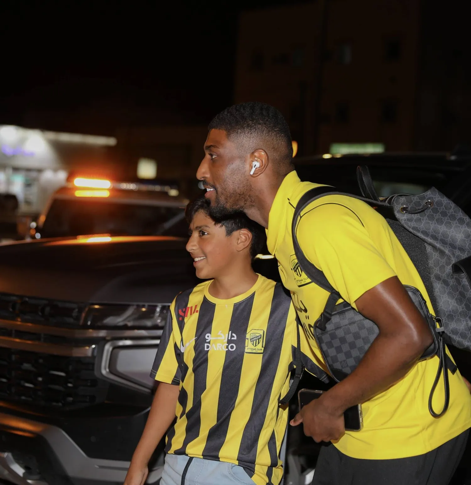 أحمد شراحيلي مدافع الاتحاد في صورة مع طفل لدى وصوله المجمعة ليلة أمس (نادي الاتحاد)