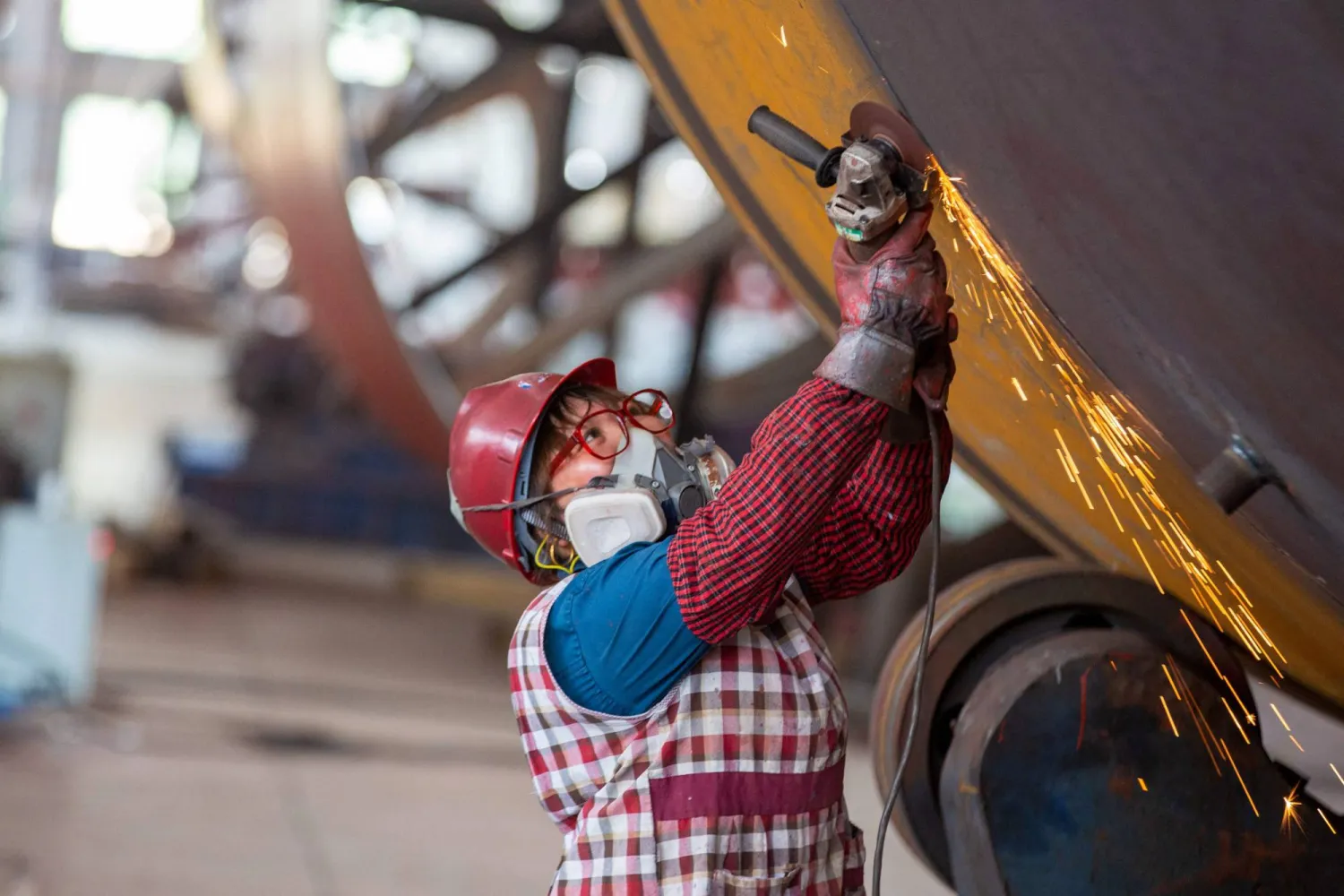 عامل يلحم أجزاء من مواد البناء في مصنع في نانتونغ بمقاطعة جيانغسو شرق الصين (أ.ف.ب)