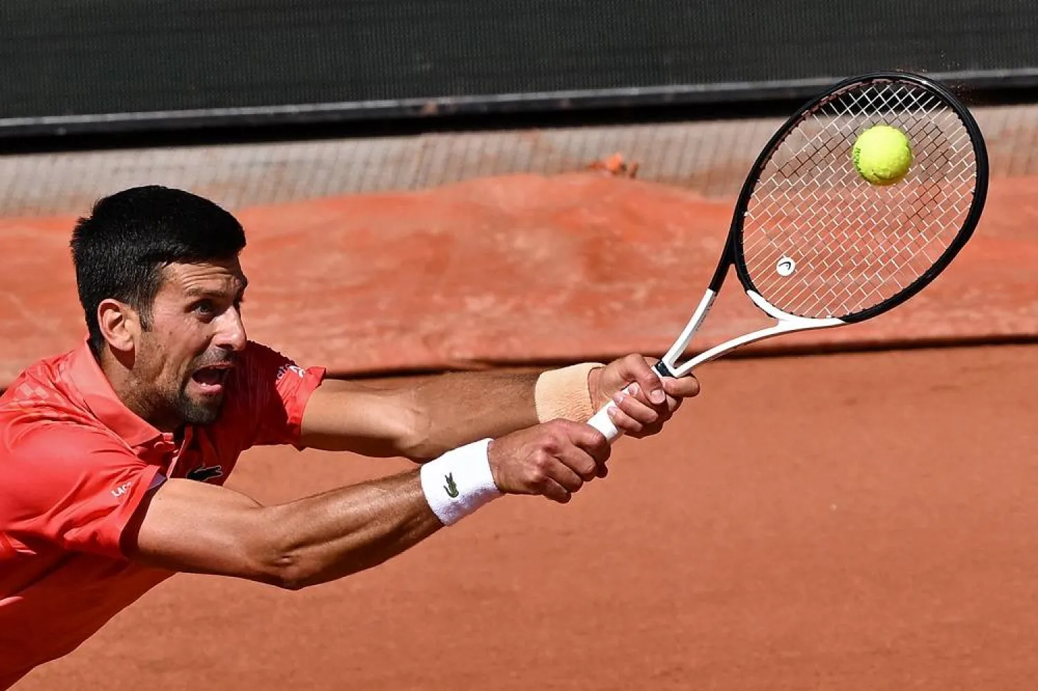 Serbia's Novak Djokovic plays a backhand return to US Aleksandar Kovacevic during their men's singles match on day two of the Roland-Garros Open tennis tournament at the Court Philippe-Chatrier in Paris on May 29, 2023. (AFP) 