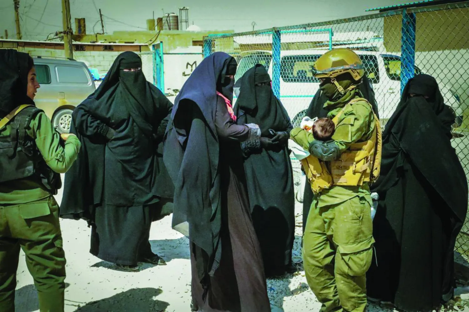 مقاتلتان كرديتان مع نساء في مخيم «الهول» (الشرق الأوسط)