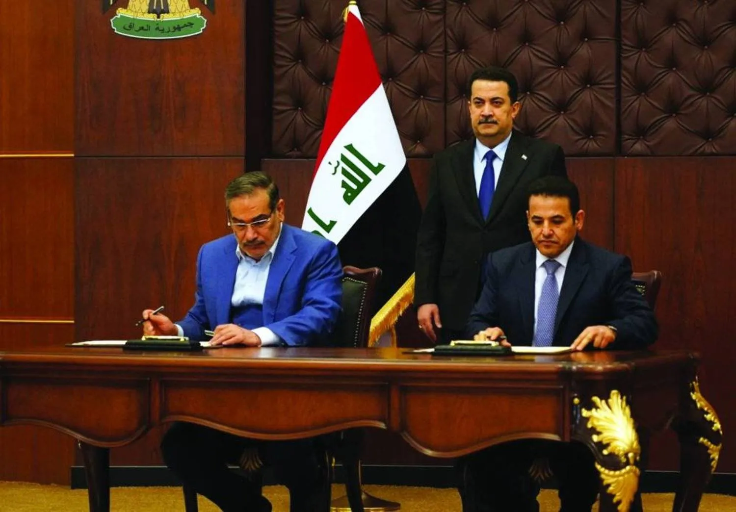  Secretary of the Iranian Supreme National Security Council Ali Shamkhani and  National Security Advisor, Qasim Al-Araji sign the agreement documents, in the presence of Al-Sudani in Baghdad in March. (Reuters)