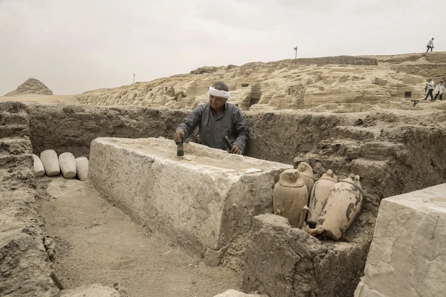 An Egyptian antiquities worker brushes a recently unearthed embalming bed at the site of the Step Pyramid of Djoser in Saqqara, 24 kilometers (15 miles) southwest of Cairo, Egypt, Saturday, May 27, 2023. (AP Photo/Amr Nabil)