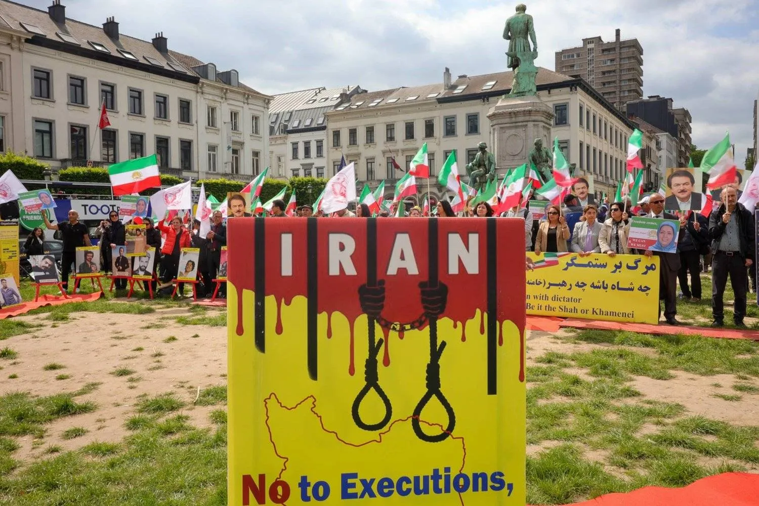 Iranians raise banners denouncing executions in a protest before the European Parliament in Brussels on May 24, 2023. (EPA) 