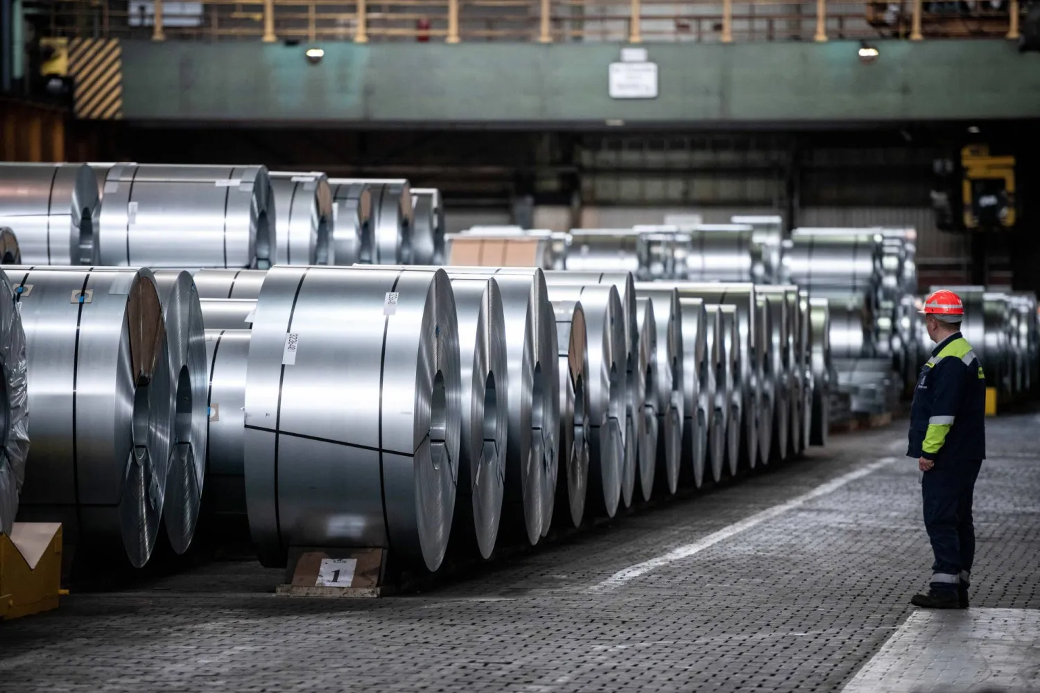 عامل أمام ملفات الصلب في مصنع الدرفلة على البارد في دويسبورغ - ألمانيا (إ.ب.أ)