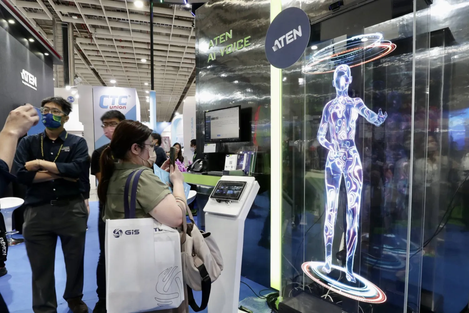 زائرون يتفاعلون مع صوت صدر من نظام ذكاء اصطناعي في تايوان (إ.ب.أ)