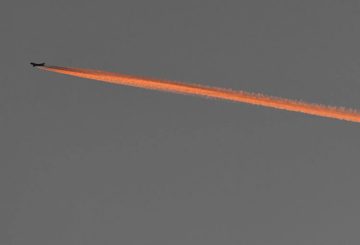 FILE PHOTO: The setting sun illuminates an aircraft's contrail as it flies, January 17, 2022. REUTERS/Toby Melville/File Photo