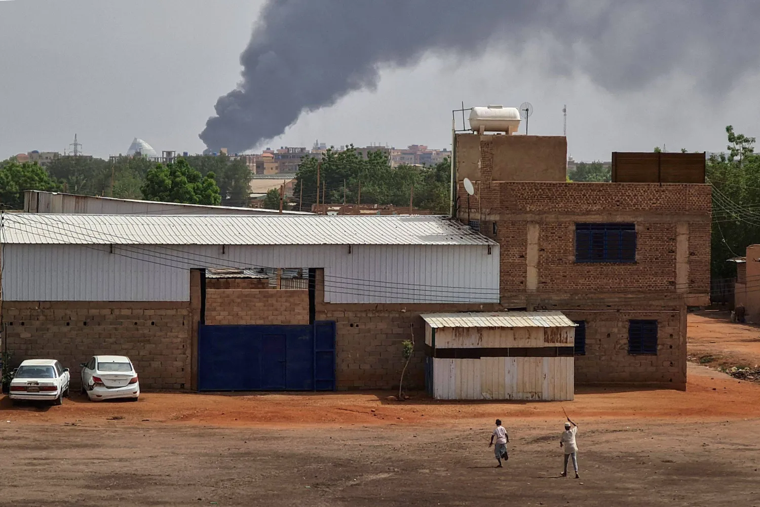 الدخان يتصاعد خلف المباني وسط استمرار القتال في الخرطوم (أ.ف.ب)