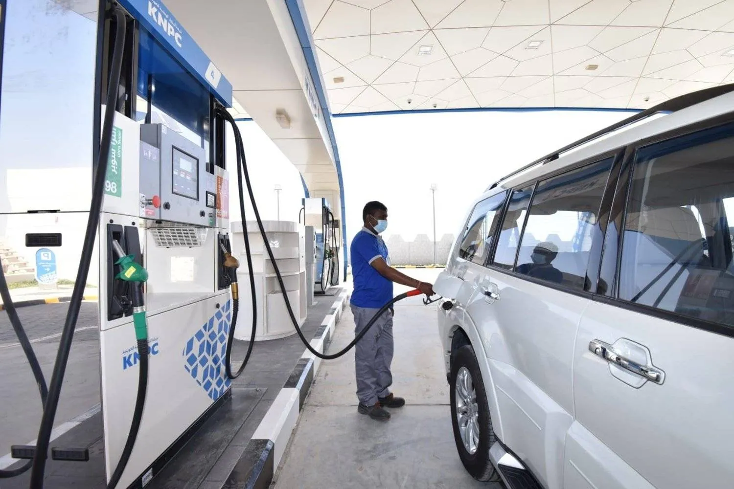 A worker fills fuel at a station in Kuwait (KUNA)