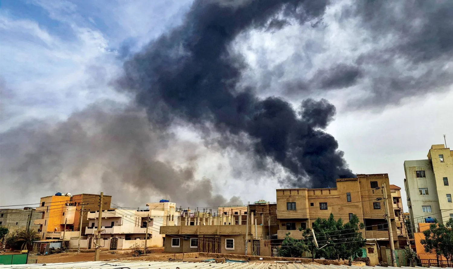  أعمدة الدخان تتصاعد من حريق في أحد المستودعات جنوب الخرطوم أمس (أ.ف.ب)