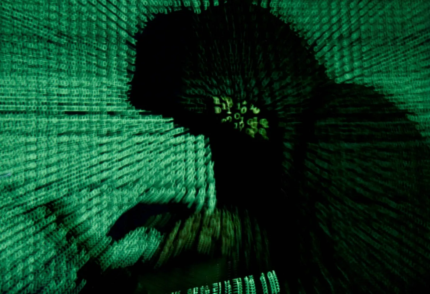 FILE PHOTO: A man holds a laptop computer as cyber code is projected on him in this illustration picture taken on May 13, 2017. REUTERS/Kacper Pempel/Illustration/File Photo