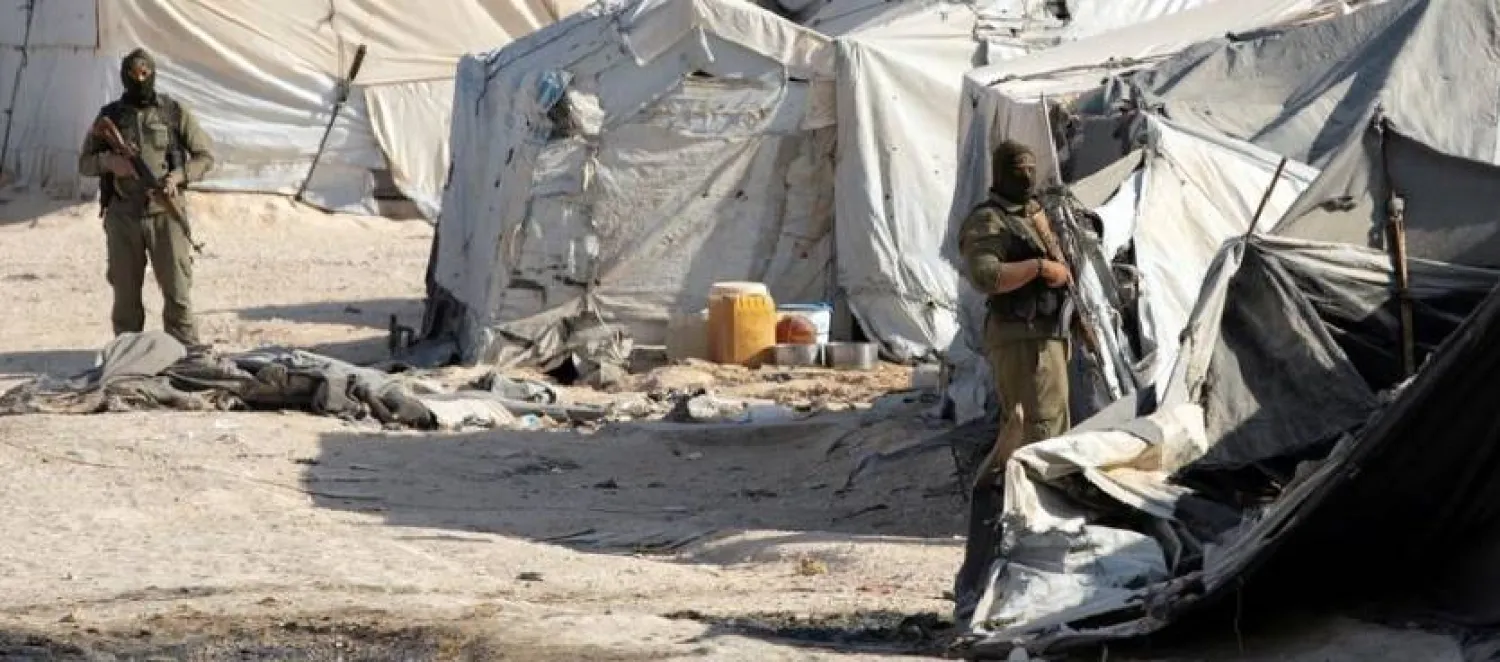 A Syrian Democratic Forces (SDF) fighter stands near Kurdish internal security special forces during a security operation in al-Hol camp which holds displaced people and families of ISIS militants, in Hasaka governorate, in northeast Syria August 26, 2022. REUTERS/Orhan Qereman