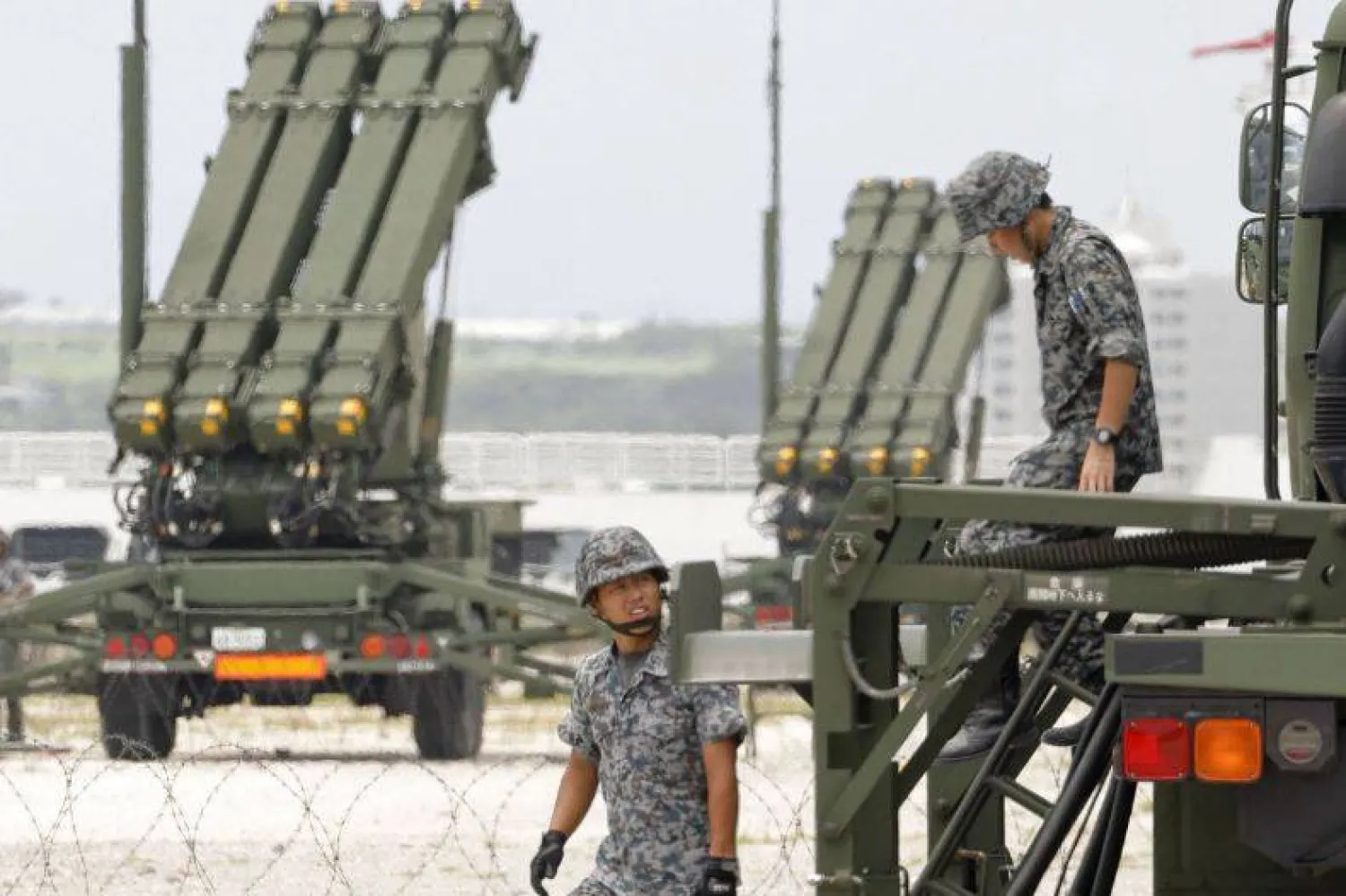 أفراد من قوة الدفاع الذاتي اليابانية يقفون بجانب بطارية باتريوت المتطورة للدفاع الصاروخي 3 (PAC-3) التي تم نشرها في إيشيجاكي بمحافظة أوكيناوا اليوم الأحد (كيودو)