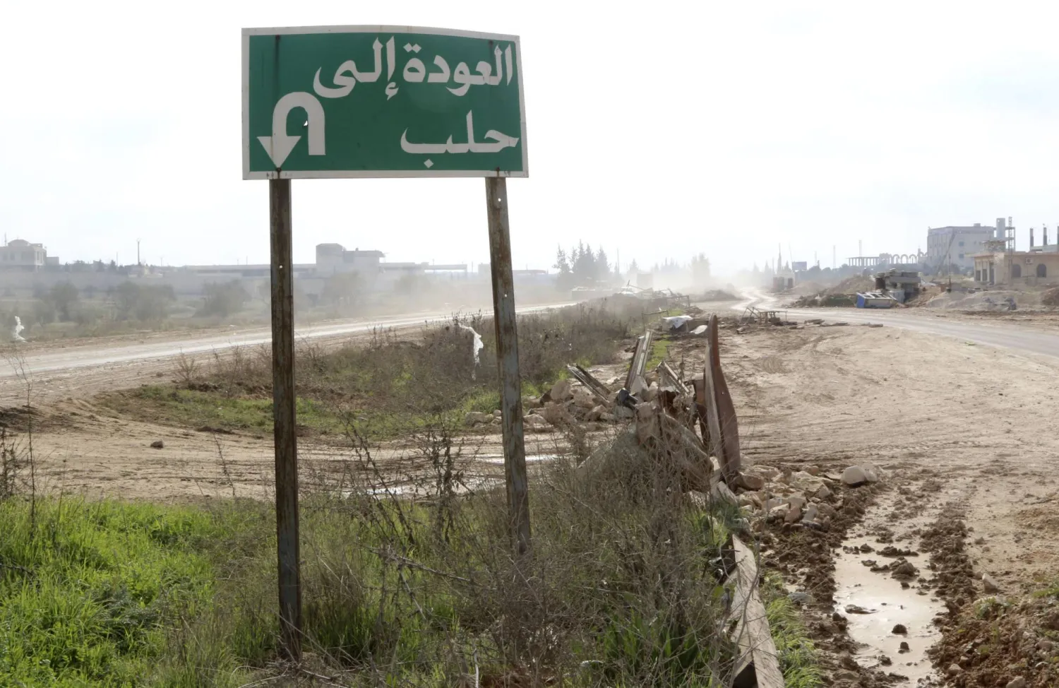 لافتة طريق كُتب عليها «العودة إلى حلب» تظهر على الطريق السريع الرئيسي بين الشمال والجنوب الذي يربط حلب بدمشق (رويترز)