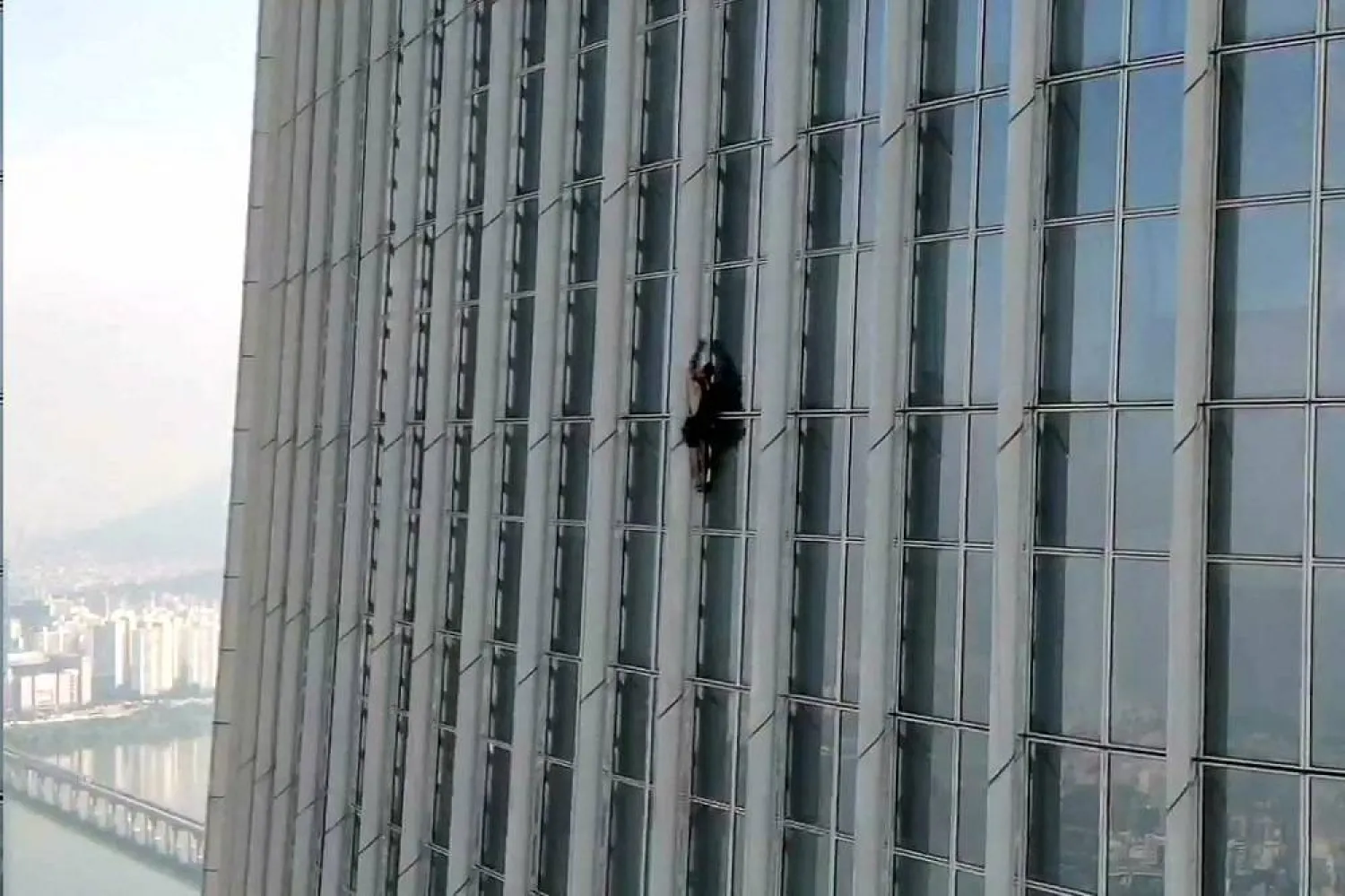This handout photo taken on June 12, 2023 and provided by the Seoul Metropolitan Fire and Disaster Management Headquarters shows a man, identified by authorities as British, climbing the exterior of the 123-story Lotte World Tower in Seoul. (AFP / Seoul Metropolitan Fire and Disaster Management Headquarters) 