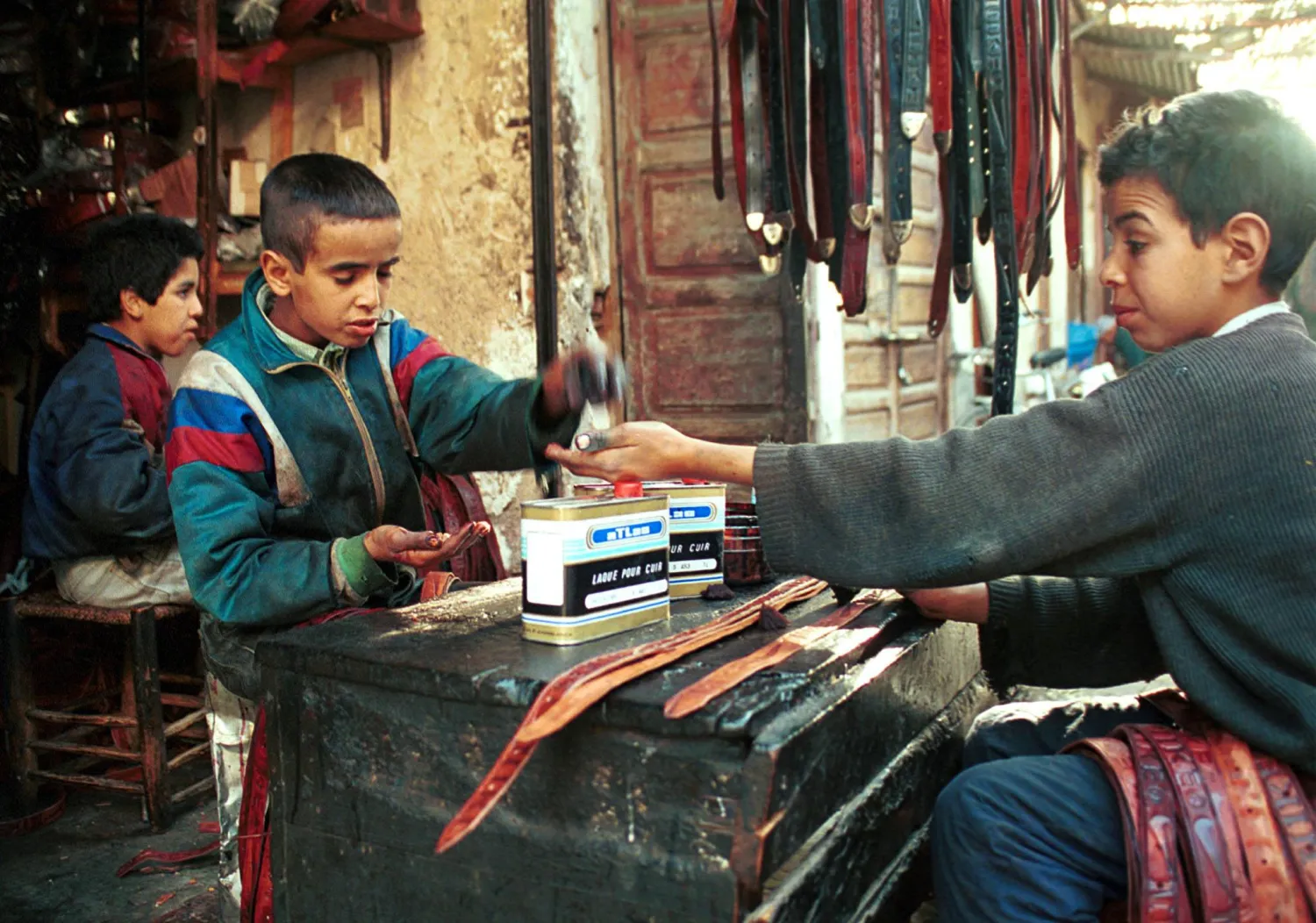 صورة أرشيفية لأطفال يعملون في بيع الأحزمة الجلدية في مراكش (رويترز).