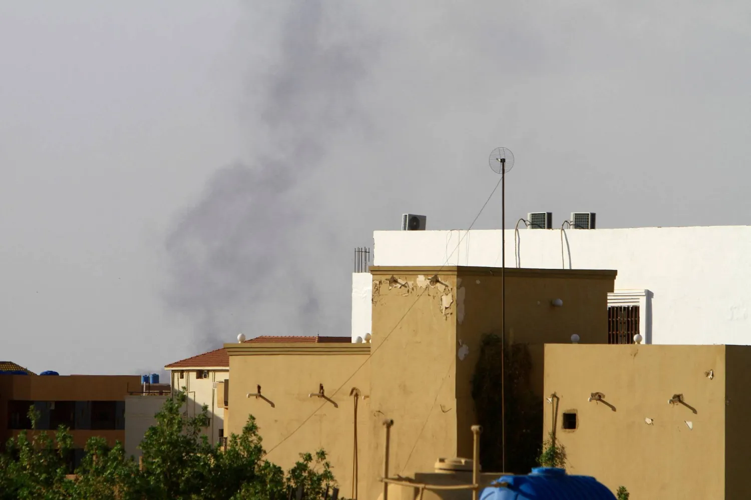 الدخان يتصاعد خلف المباني في الخرطوم (أ.ف.ب)