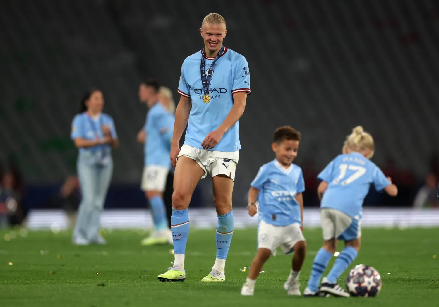 هالاند يشاهد طفلين يلعبان الكرة عقب تتويج مانشستر سيتي بالبريميرليغ (إ.ب.أ)