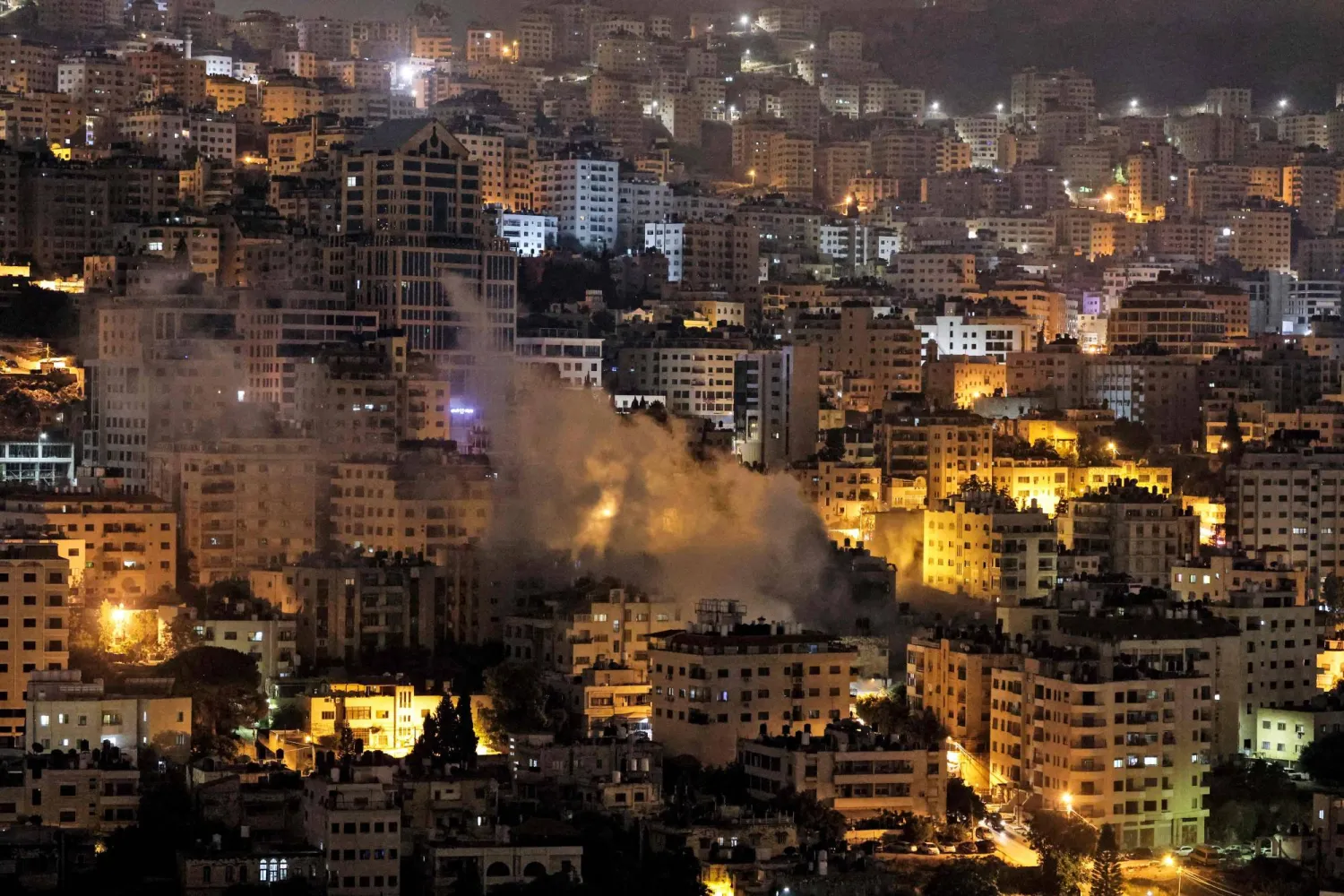 دخان يتصاعد في نابلس بوقت مبكر الخميس بعد اقتحام الجيش الإسرائيلي لها (أ.ف.ب)