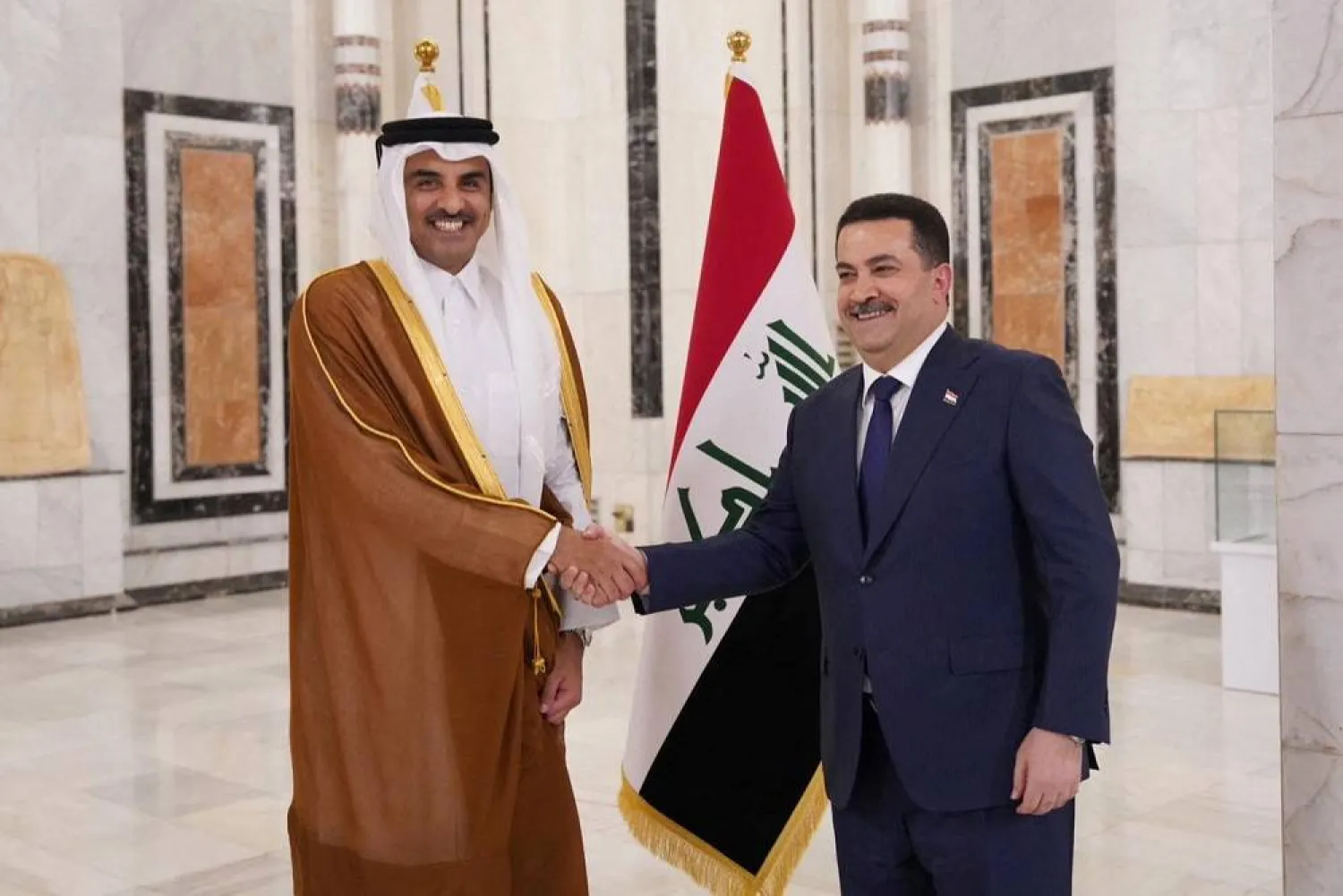 Iraqi Prime Minister Mohammed Shia al-Sudani shakes hands with Qatar's Emir Sheikh Tamim bin Hamad al-Thani during a welcome ceremony, in Baghdad, Iraq June 15, 2023. (Iraqi Prime Minister Media Office/Handout via Reuters) 