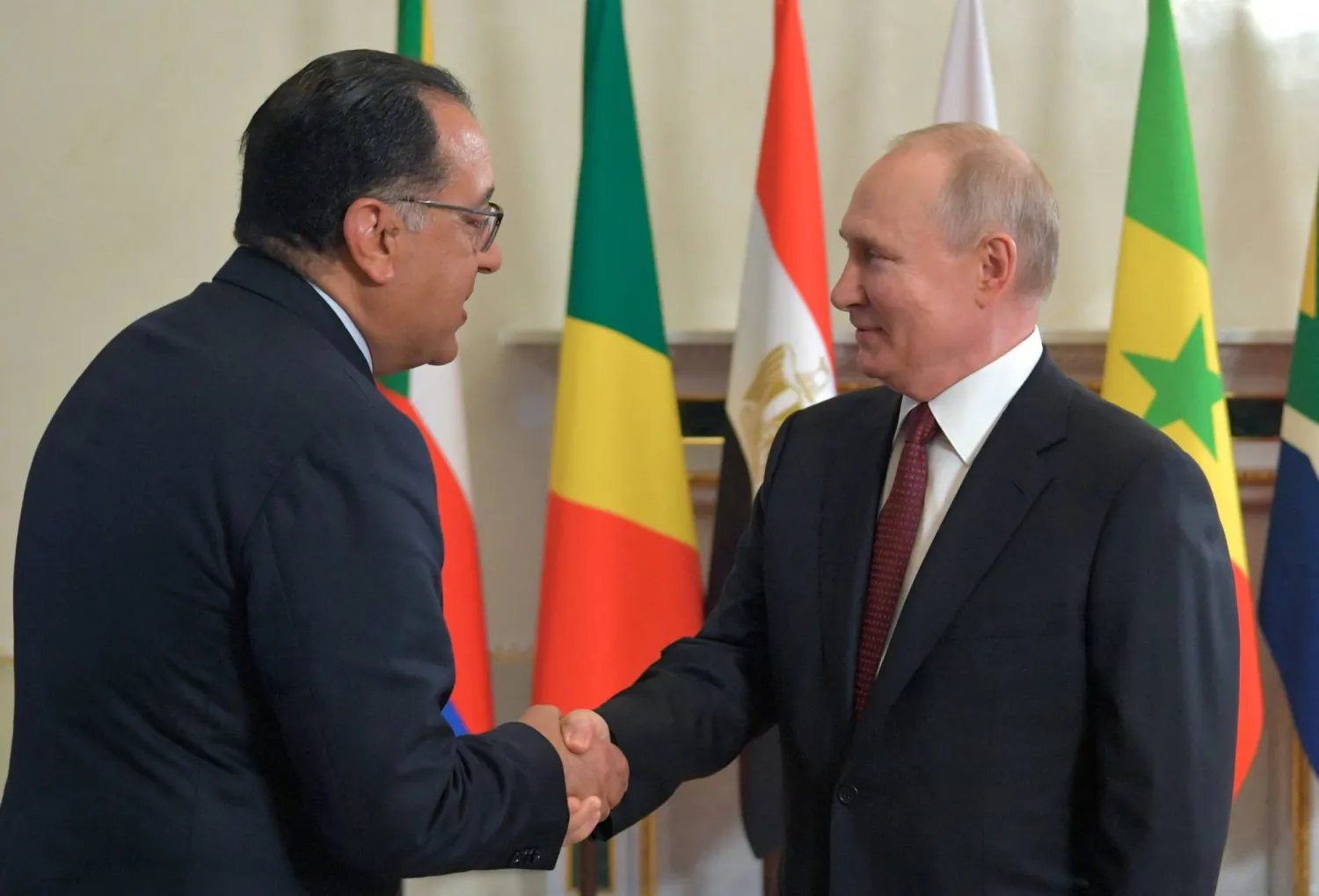 الرئيس الروسي فلاديمير بوتين يصافح رئيس الوزراء المصري مصطفى مدبولي (رويترز)