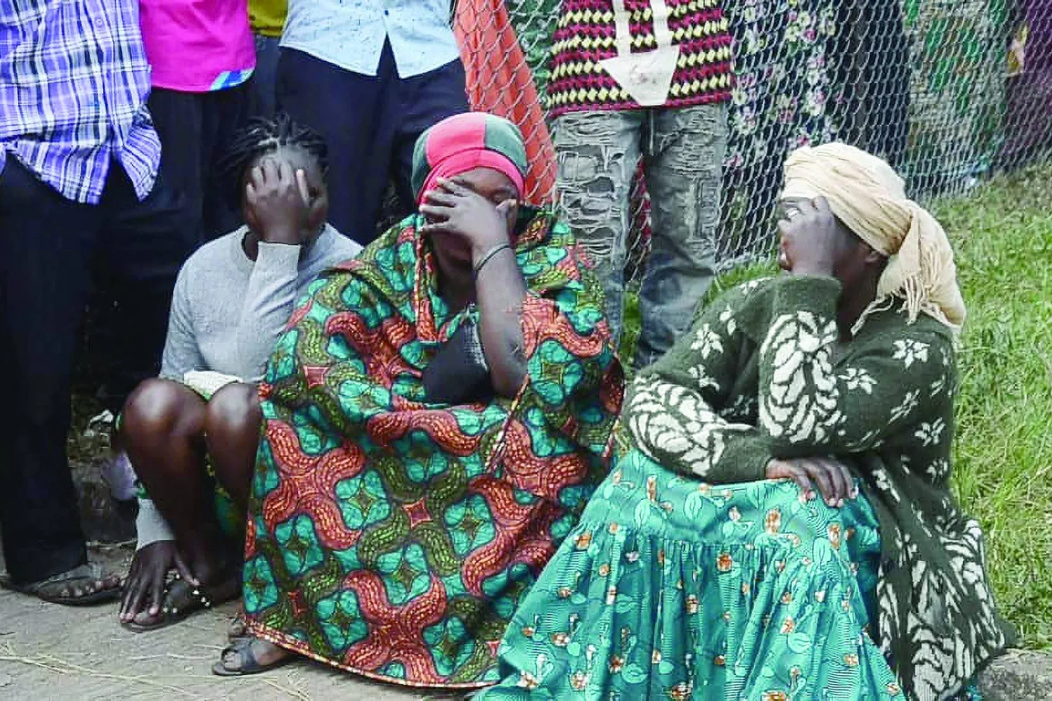 سكان من بلدة مبوندوي الحدودية بأوغندا في حالة تأثر بعد مجزرة مدرسة «لوبيريها» الثانوية (أ.ف.ب)