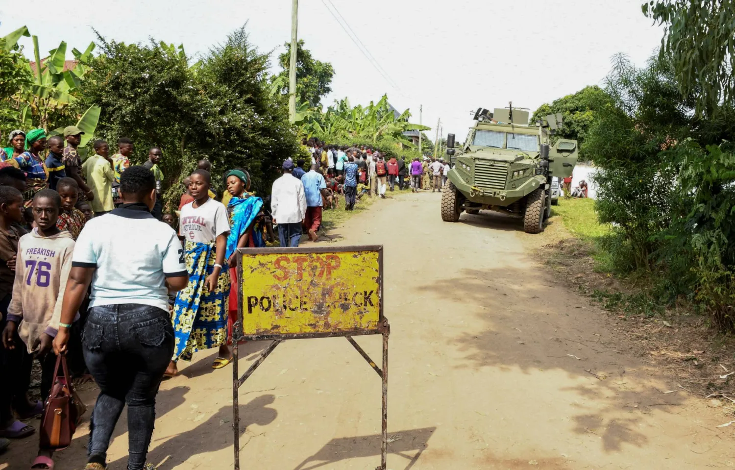 Locals gather at the cordoned scene outside the Mpondwe Lhubirira Secondary School, after the attack in Mpondwe, western Uganda, June 17, 2023. REUTERS/Stringer 