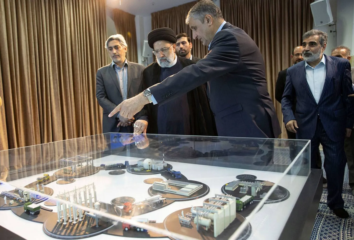 صورة نشرتها «الذرية» الإيرانية من رئيسها محمد إسلامي يشرح لرئيسي دورة العمل في منشأة نووية