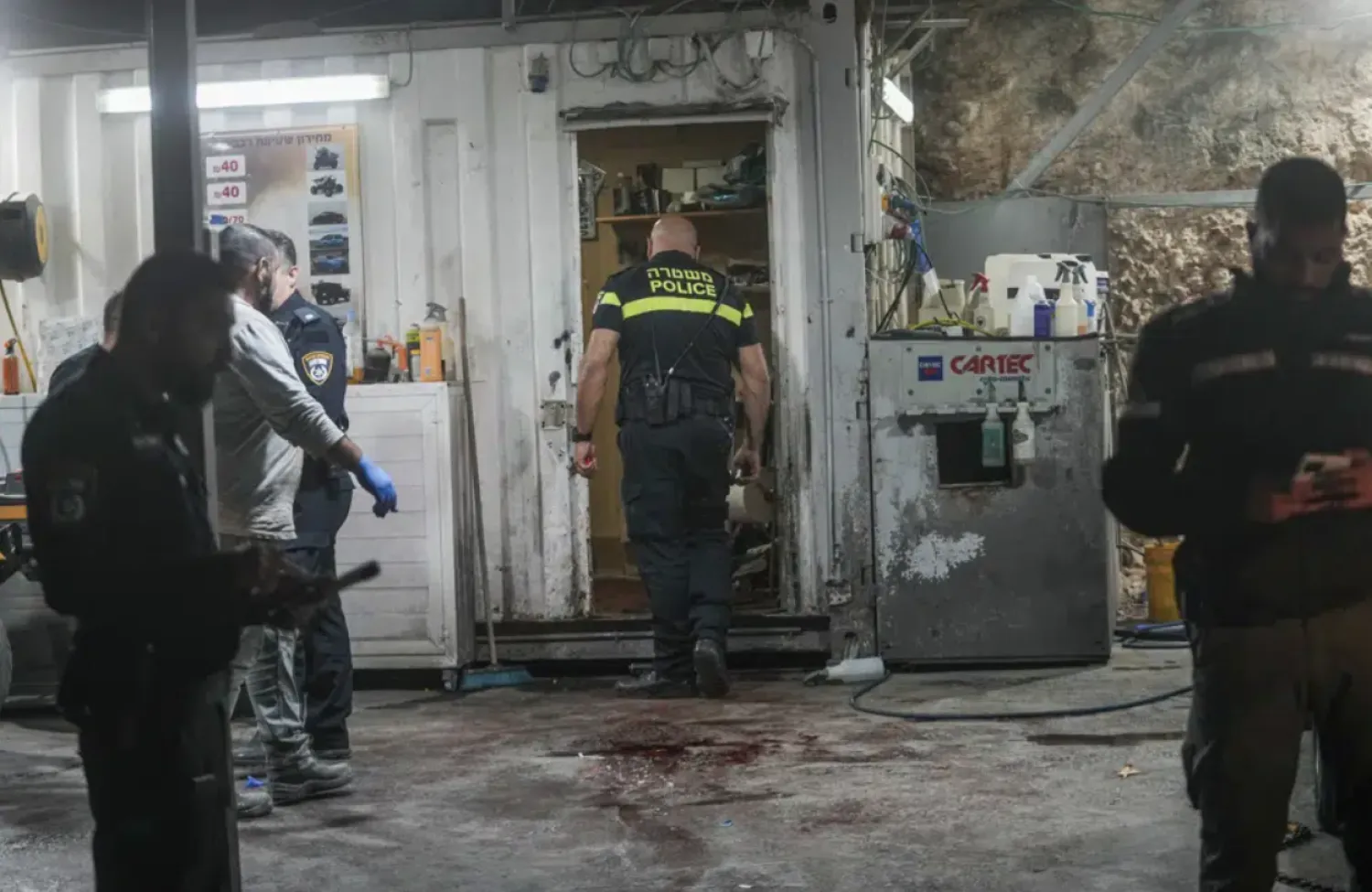 Israeli police examine the crime scene where a gunman opened fire at a car wash in Yafa an-Naseriyye, near Nazareth, Israel, Thursday, June 8, 2023. (AP Photo/Mahmoud Illean)
