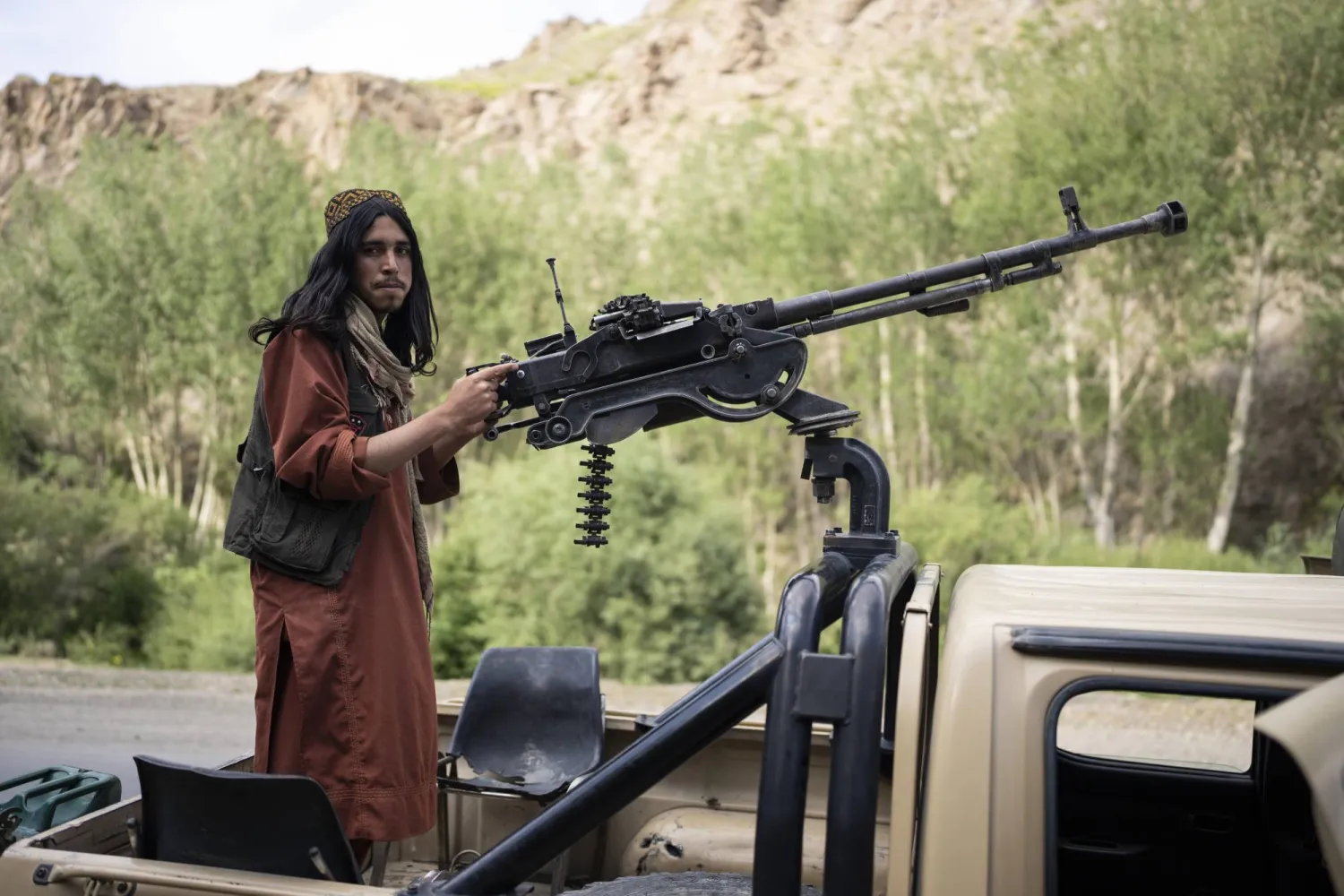 مقاتل من «طالبان» يقف على ظهر شاحنة صغيرة على طريق في ولاية وردك بأفغانستان الأحد (أ.ب)