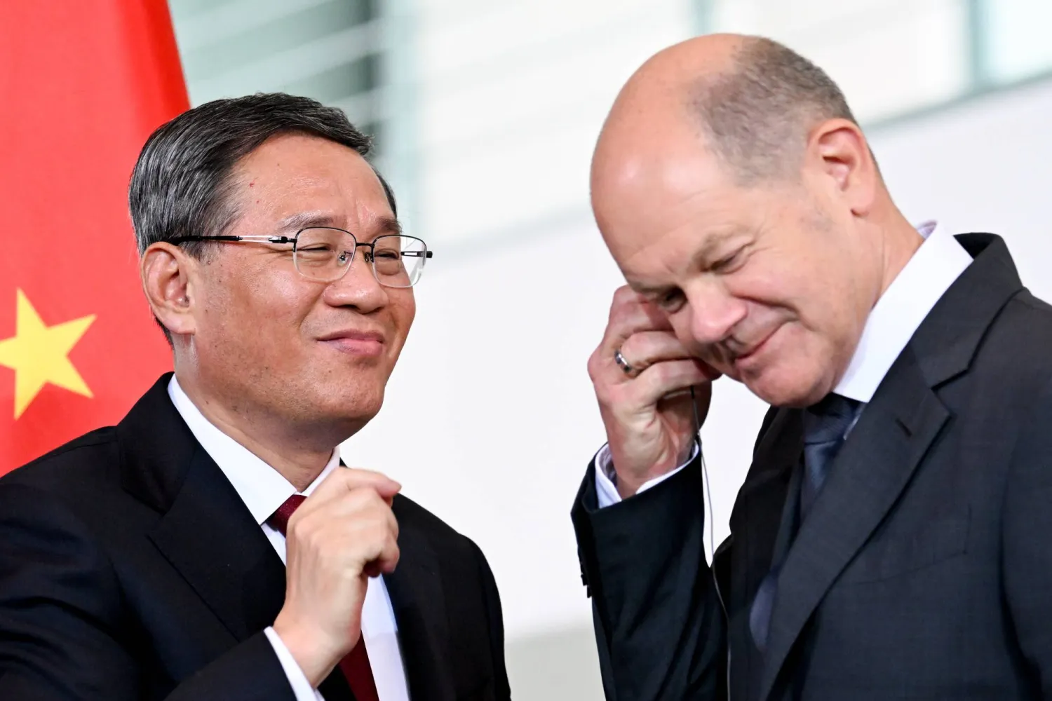 المستشار الألماني أولاف شولتس (يمين) ورئيس الوزراء الصيني لي تشيانغ بعد مؤتمر صحافي خلال المشاورات الحكومية الألمانية - الصينية اليوم في برلين (إ.ب.أ)