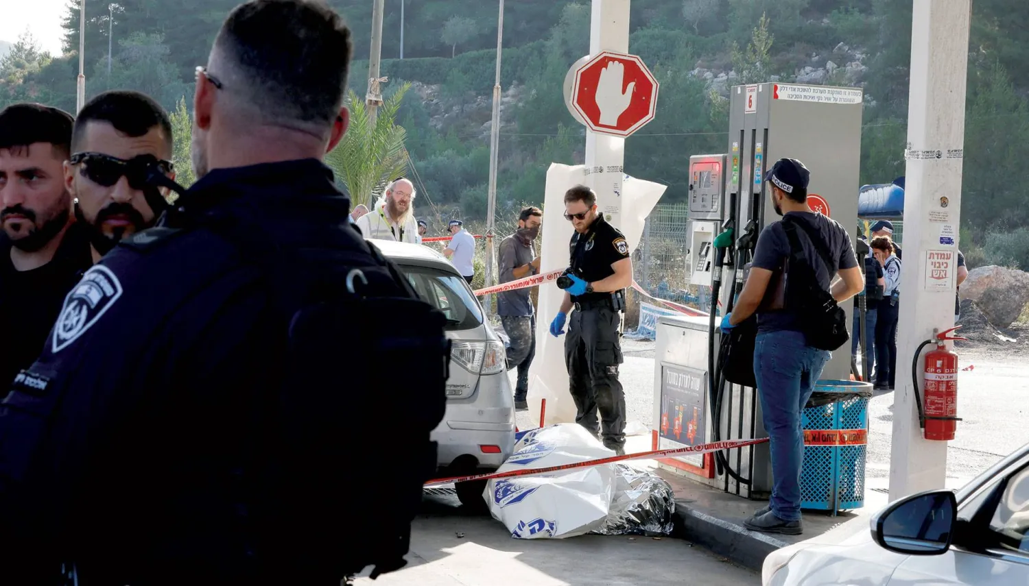 عناصر أمن أمام موقع إطلاق النار على مستوطنة عيلي في الضفة الغربية أمس (رويترز)