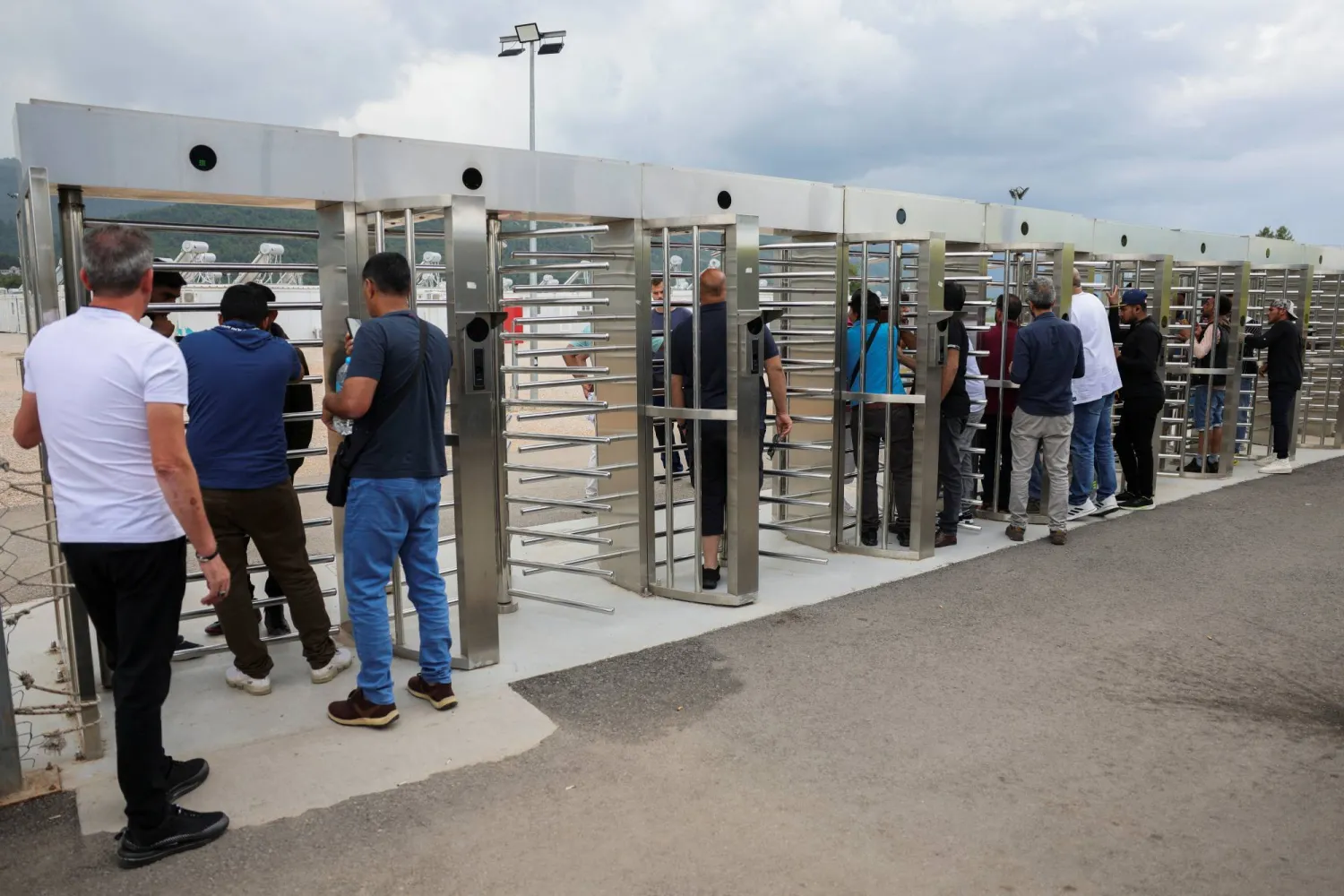 أقارب وأصدقاء خلف الحاجز المحيط بمخيم مالاكاسا للمهاجرين الناجين يحاولون معرفة أي شيء عن المفقودين (رويترز)