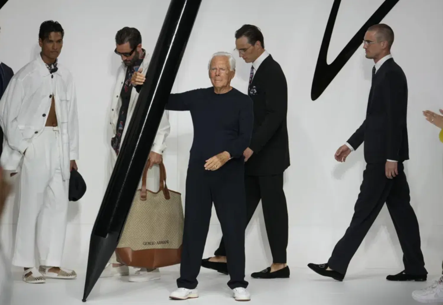 Designer Giorgio Armani receives applause at the end of the Giorgio Armani men's Spring Summer 2024 fashion show presented in Milan, Italy, Monday, June 19, 2023. (AP Photo/Luca Bruno)
