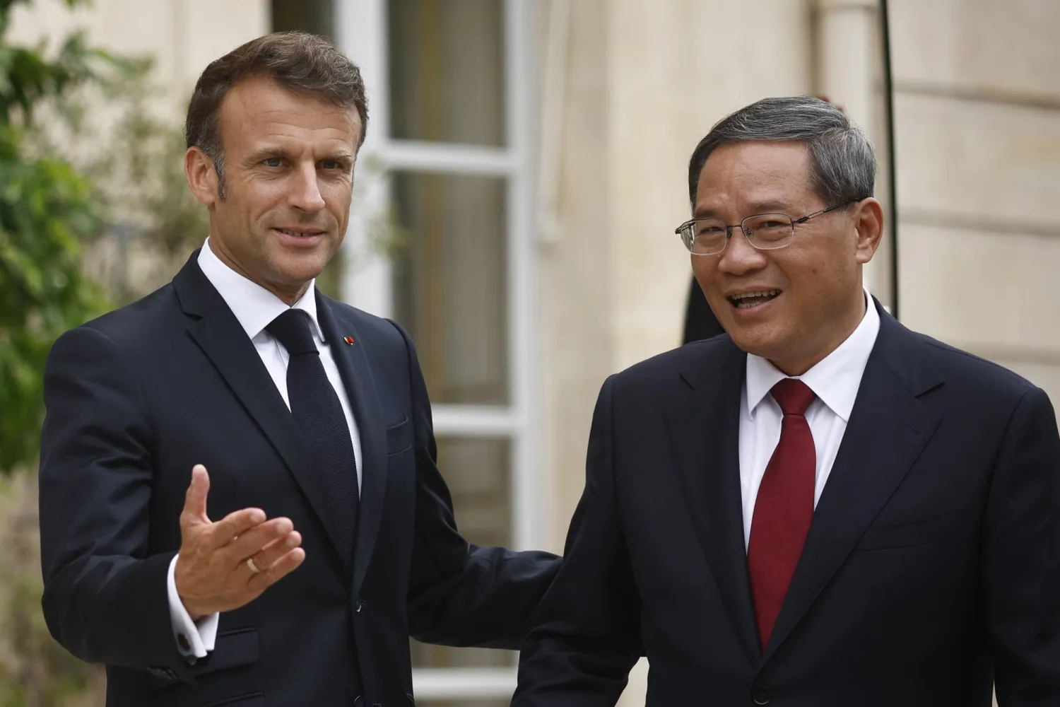 رئيس الوزراء الصيني لي تشيانغ (يمين) والرئيس الفرنسي إيمانويل ماكرون (يسار) (إ.ب.أ)