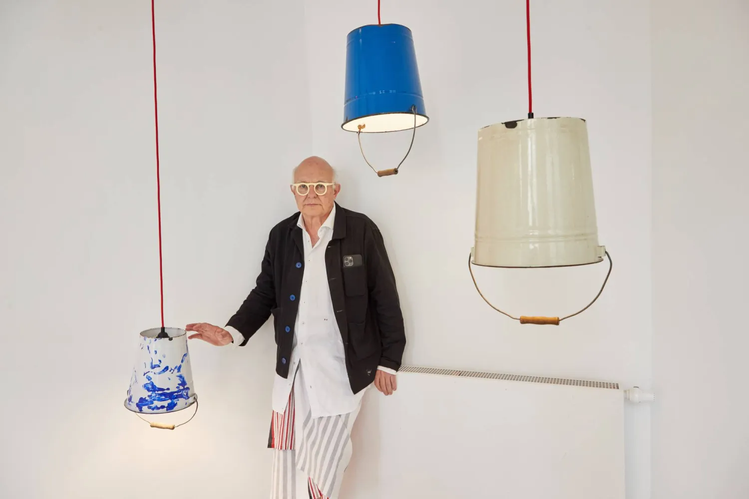 رولف زاكس وسط عمله الفني "الادلاء القصدير" في هامبورغ (د.ب.ا)